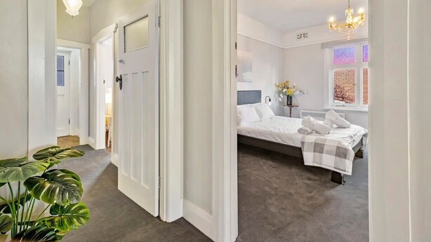 A bedroom with a bed, bedside table, and a window with a view.
