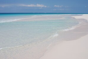 Una playa con agua turquesa cristalina y arena blanca.
