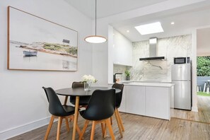Enjoy meals in this kitchen with a stainless steel refrigerator, microwave, and pendant light above the island.