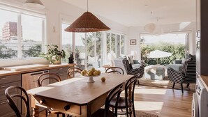 Un comedor amplio con una mesa de madera, sillas y una lámpara colgante.