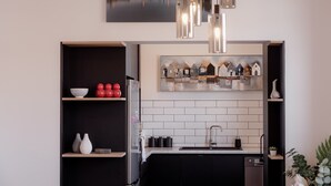 A modern kitchen with a black and white color scheme, featuring a built-in oven, a sink, and a countertop with a potted plant. - 3 Bedroom, Spacious Inner-City Pad (Hobart)