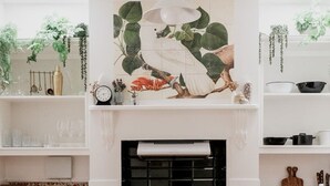 A kitchen with a central island, a stove, and a hanging light fixture above.