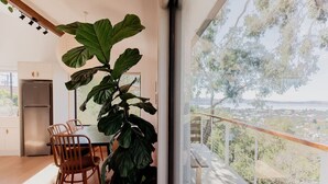 Una cocina moderna con comedor, ventanas amplias y vistas a un paisaje urbano.
