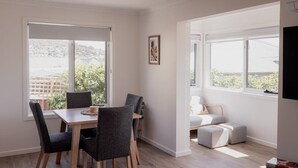 A modern living room with a dining area, large windows, and a view of the city. - Modern refurbished unit in charming Bellerive (Bellerive)