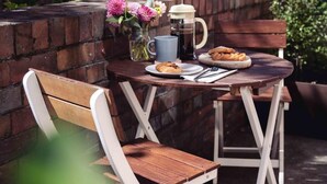 A patio with a table set for two, featuring a coffee pot, a mug, and a plate of food. - Sayer Gardens Apartment (Sandy Bay)