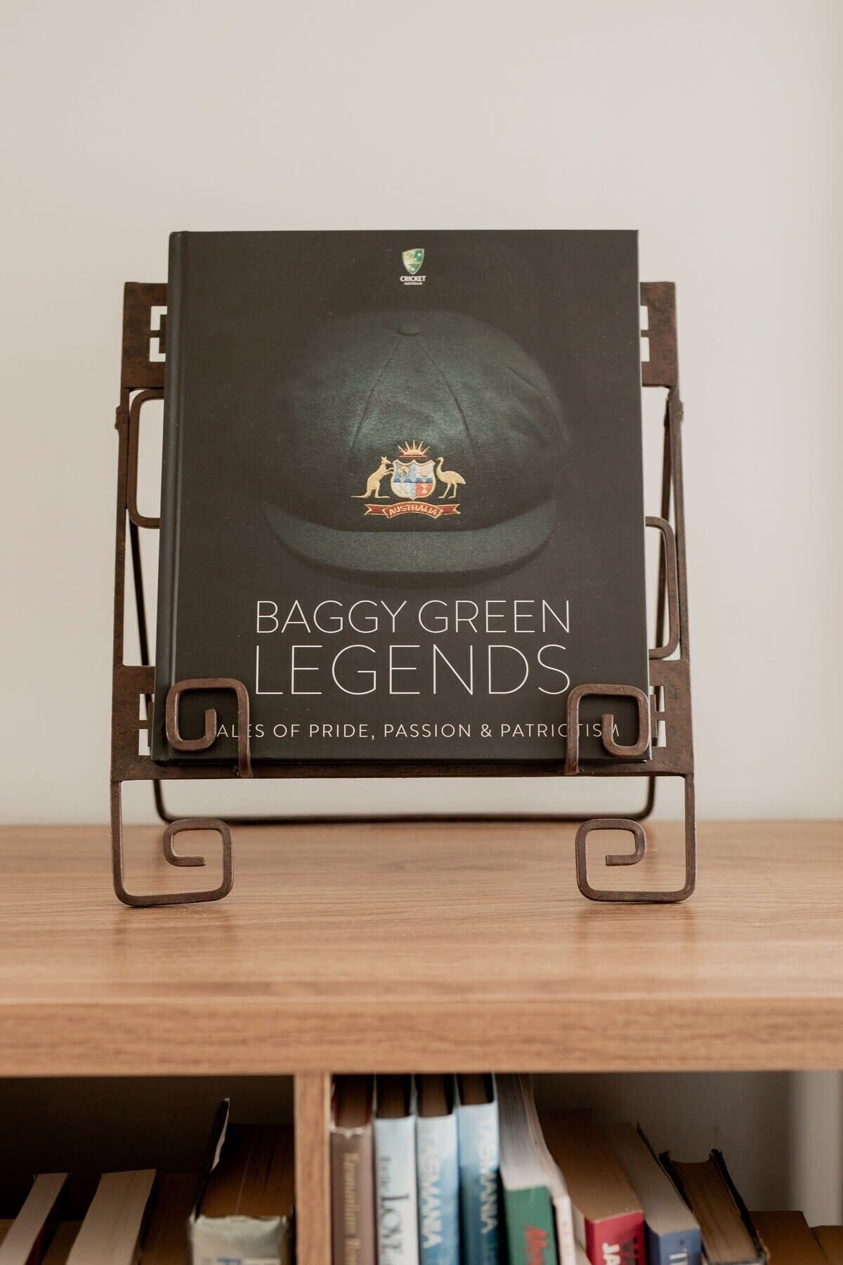 Un livre intitulé « BaggY Green Legends » est posé sur un présentoir en métal.