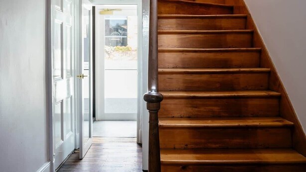 A wooden staircase leading to an upper floor, with a door at the bottom. - The Parlour Summary: (Hobart)