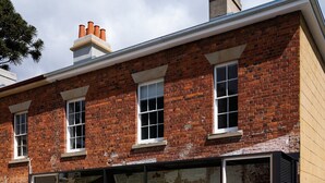 A modern building with large glass windows and a brick facade. - The Parlour Summary: (Hobart)