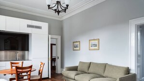 A living room with a sofa, dining table, chairs, and a chandelier. - The Parlour Summary: (Hobart)