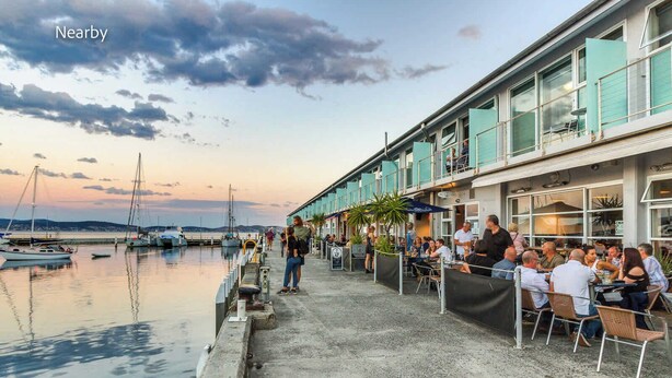 Un ristorante sul lungomare con posti a sedere all'aperto con vista su un porto turistico.