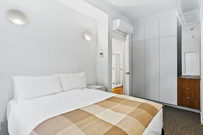 A hotel room with a bed, a wardrobe, and a small desk with a mirror. - Historical Victoria Tavern Three (Hobart)