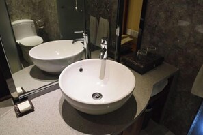 Un baño con lavamanos blanco, un espejo y un inodoro.