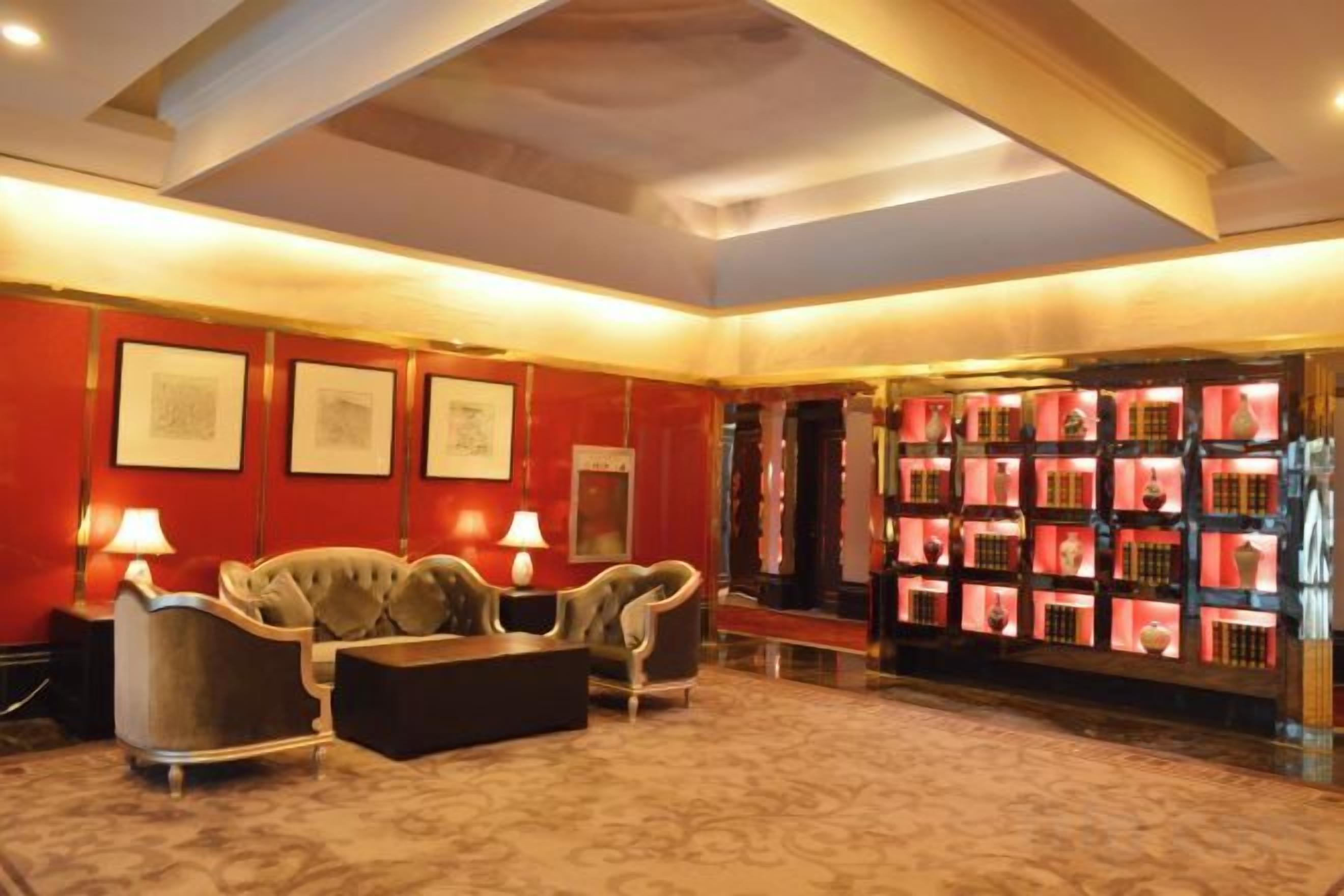 A lobby with a sofa set, framed artwork, and a display of red boxes.