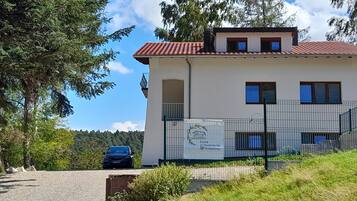 A two-story building with a red-tiled roof, a gated entrance, and a sign indicating a spa.