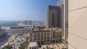 Un edificio alto con vistas a un paisaje urbano y una amplia plaza abierta con fuentes.