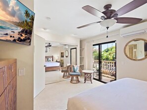 Spacious bedroom with a king bed, comfortable seating, air conditioning, and direct access to the private lanai.