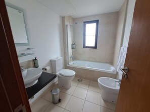 A bathroom with a toilet, bidet, sink, and bathtub. - Tortuga Beach Apartment Oasis (Sal)