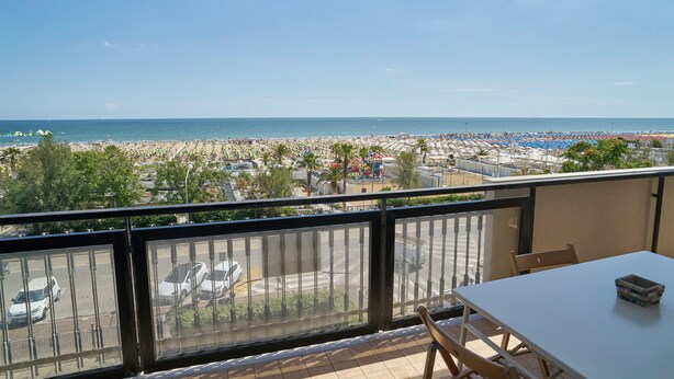 A balcony with a view of a beach and parking area. - Casa Clementina - One Bedroom Apartment, Sleeps 4 (Rimini)