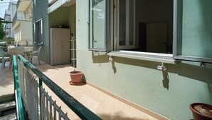 A building with a green exterior, a white door, and a window with a white frame.