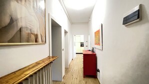 En gang med en træbænk, en radiator og et rødt skab.
