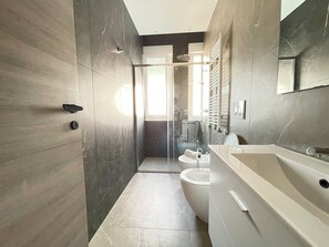 Een douche, een haardroger, een bidet, handdoeken