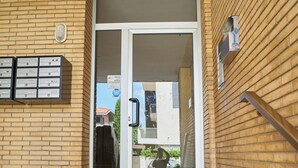 A building entrance with a glass door, a mailbox, and a wooden handrail. - Casa Mavia - Two Bedroom Apartment, Sleeps 4 (Rivabella)