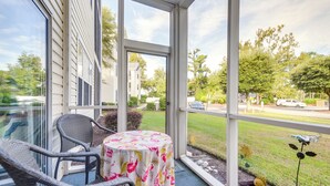 A covered porch with wicker chairs and a table, overlooking a residential street. - 2 Mi to Beach: Grand Strand Condo w/ Pool Access! (North Myrtle Beach)