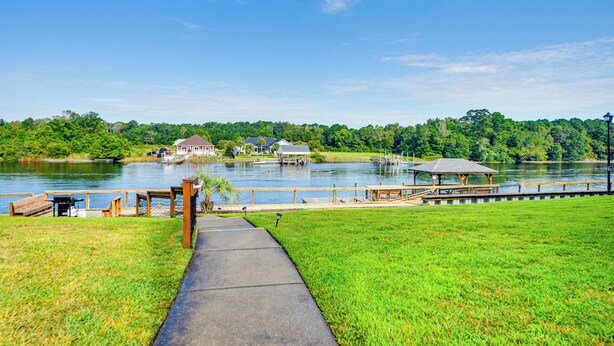 A lakeside walkway with a gazebo, picnic tables, and a dock extending into the water. - 2 Mi to Beach: Grand Strand Condo w/ Pool Access! (North Myrtle Beach)