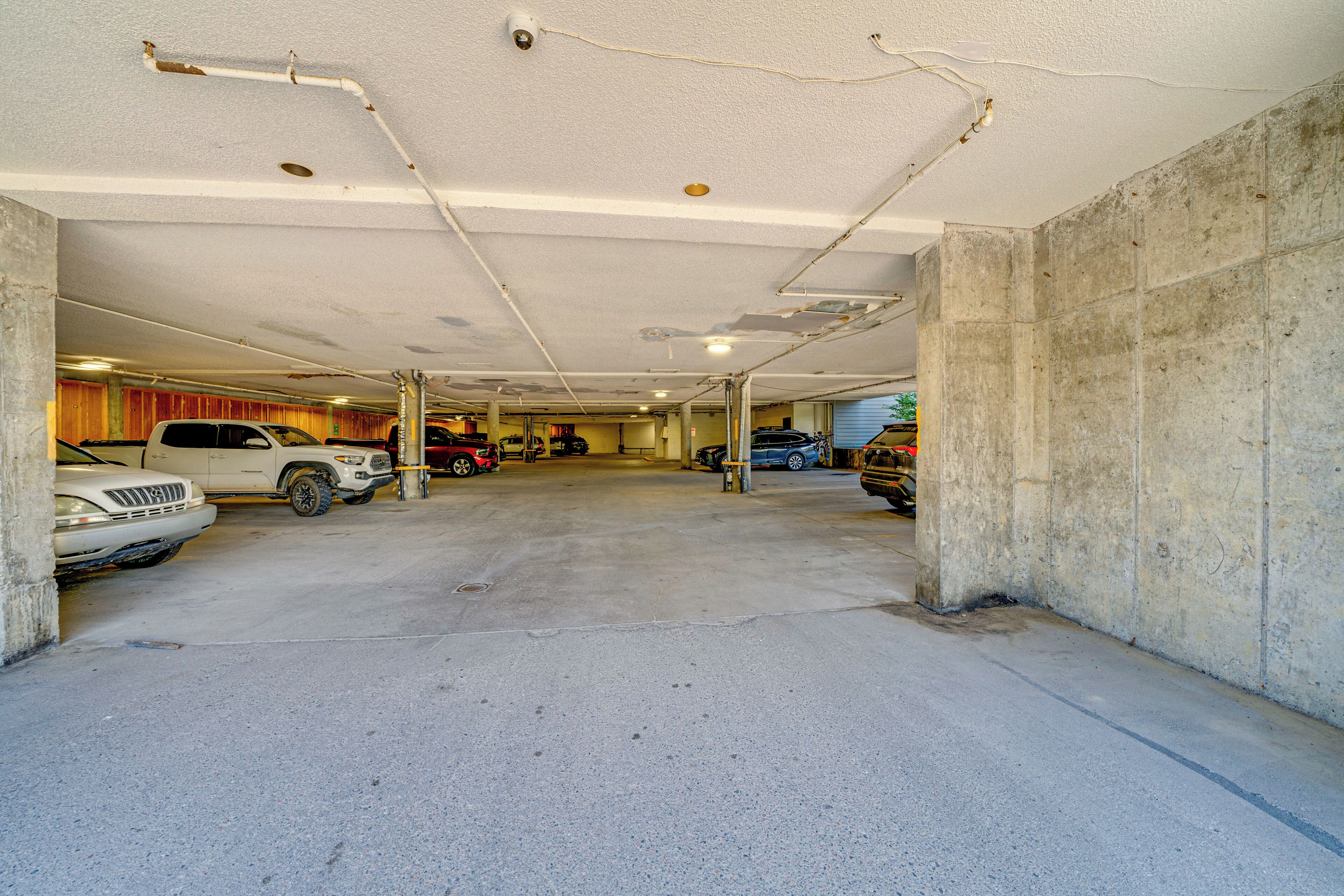 A multi-level parking garage with concrete walls and a flat ceiling.