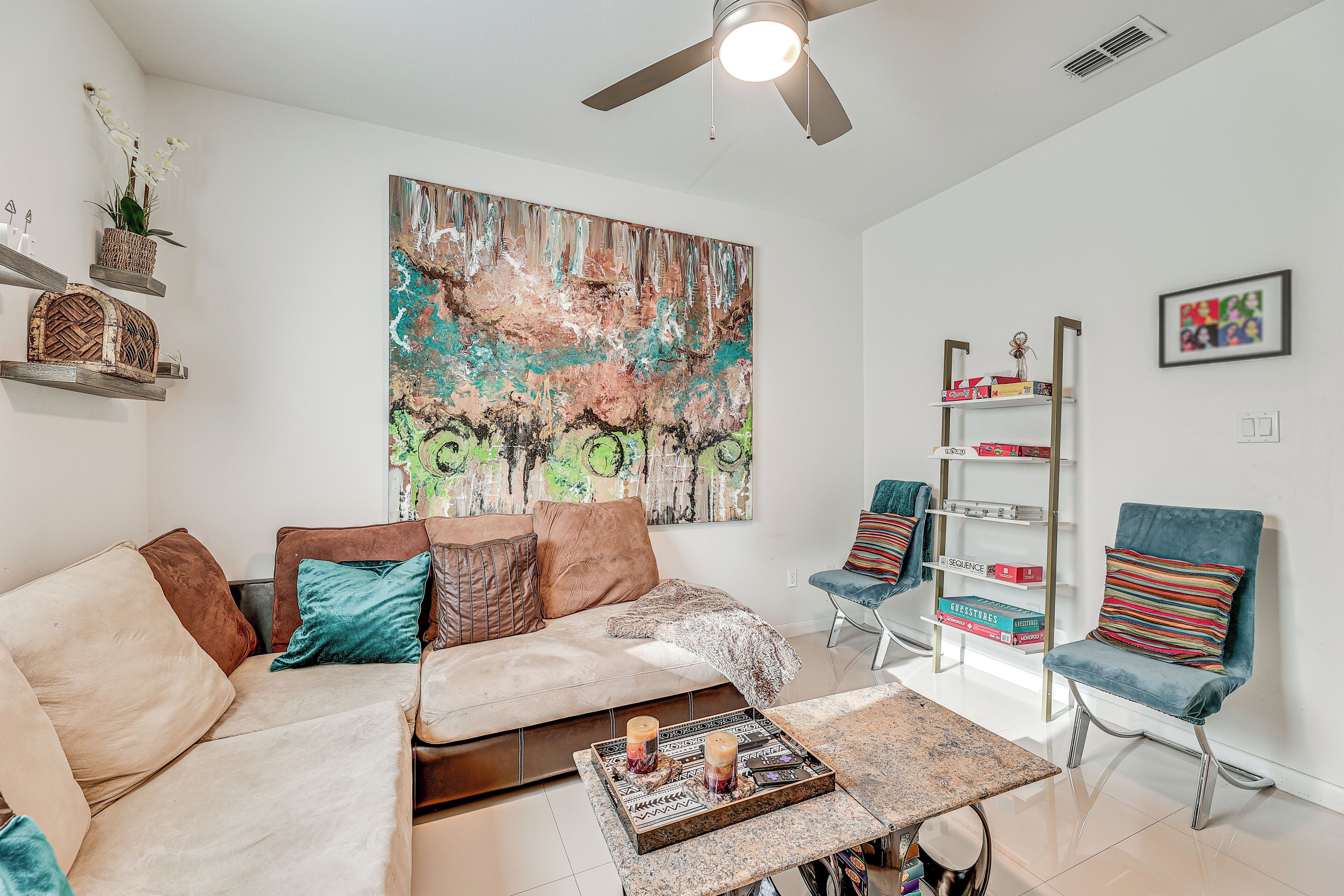 A modern living room with a sofa, chairs, a coffee table, and a bookshelf.