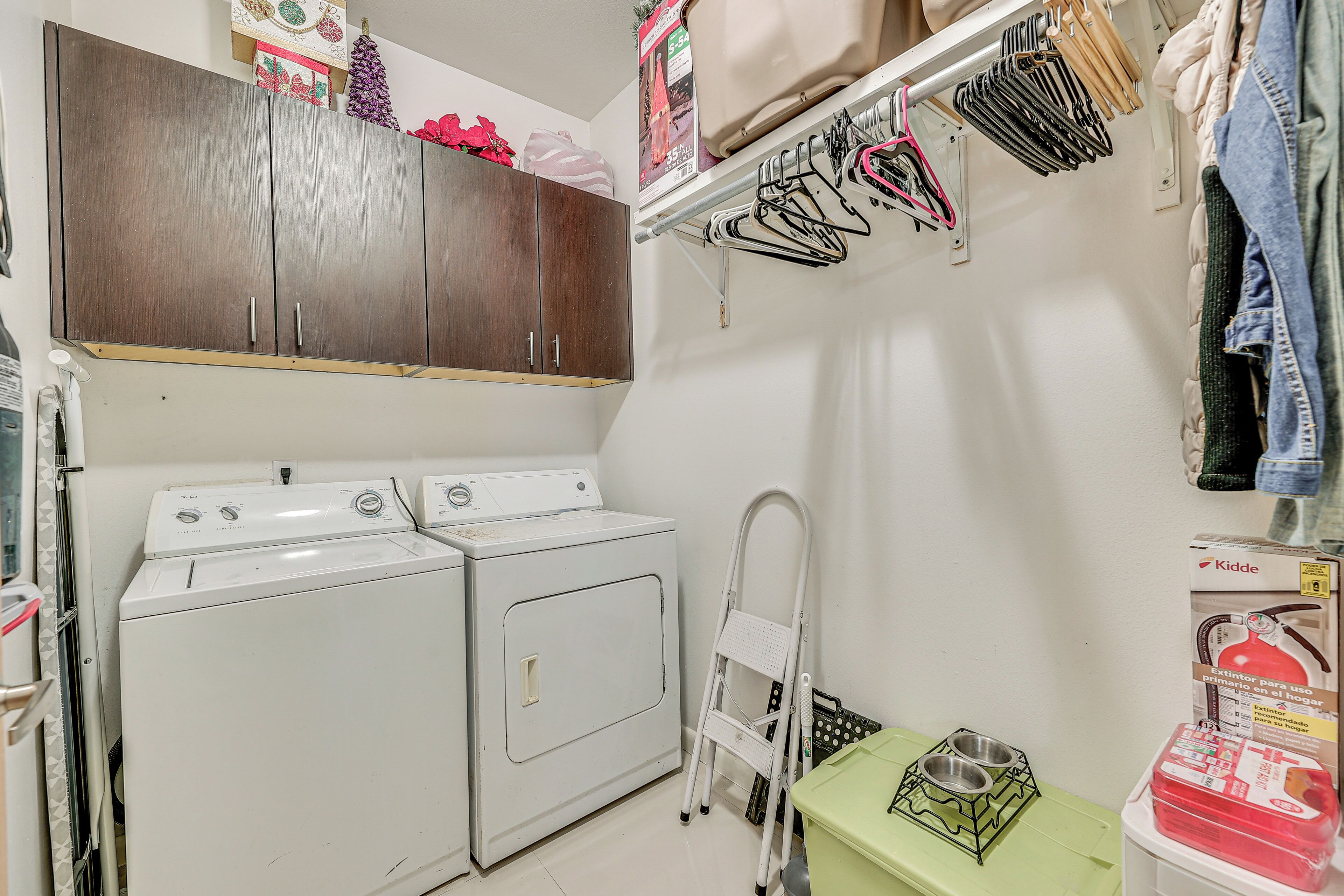 Une buanderie équipée d’un lave-linge, d’un sèche-linge et d’un étendoir.