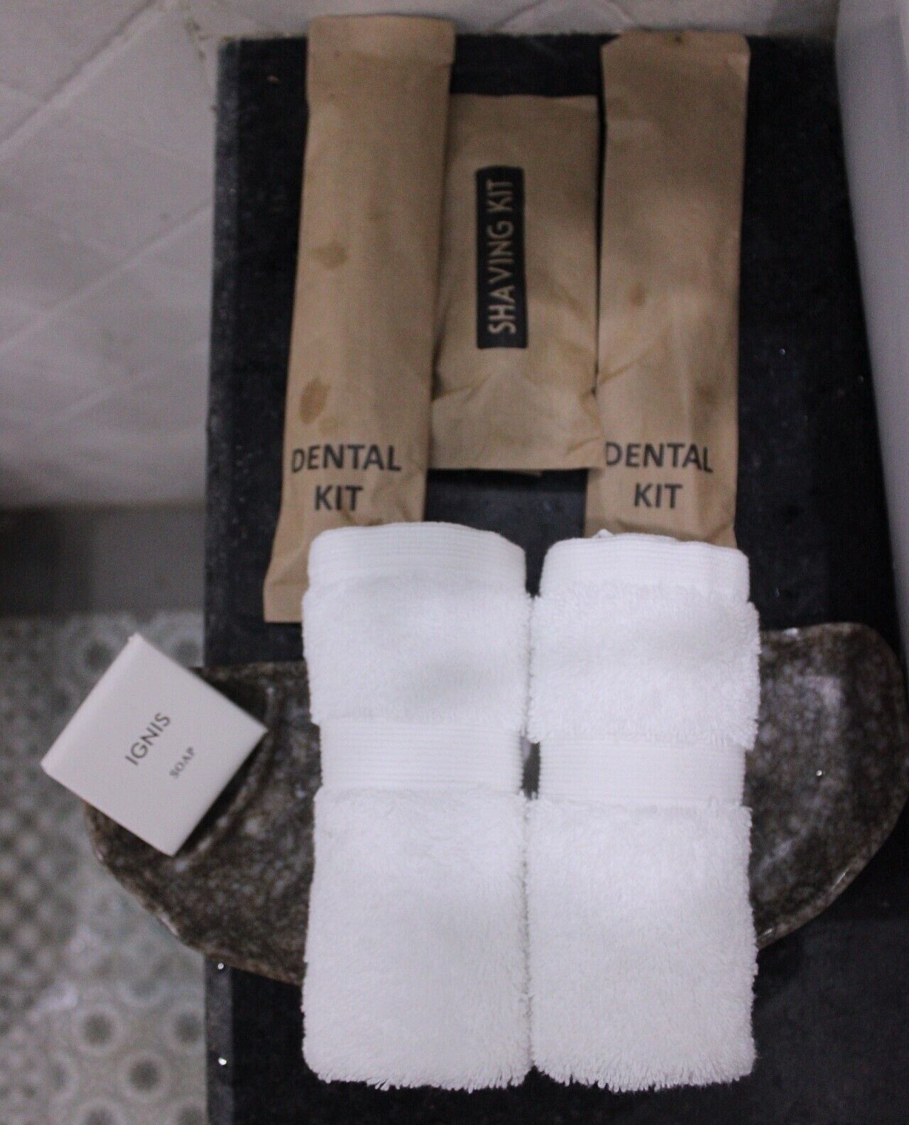 A dental kit and two white towels on a tray.