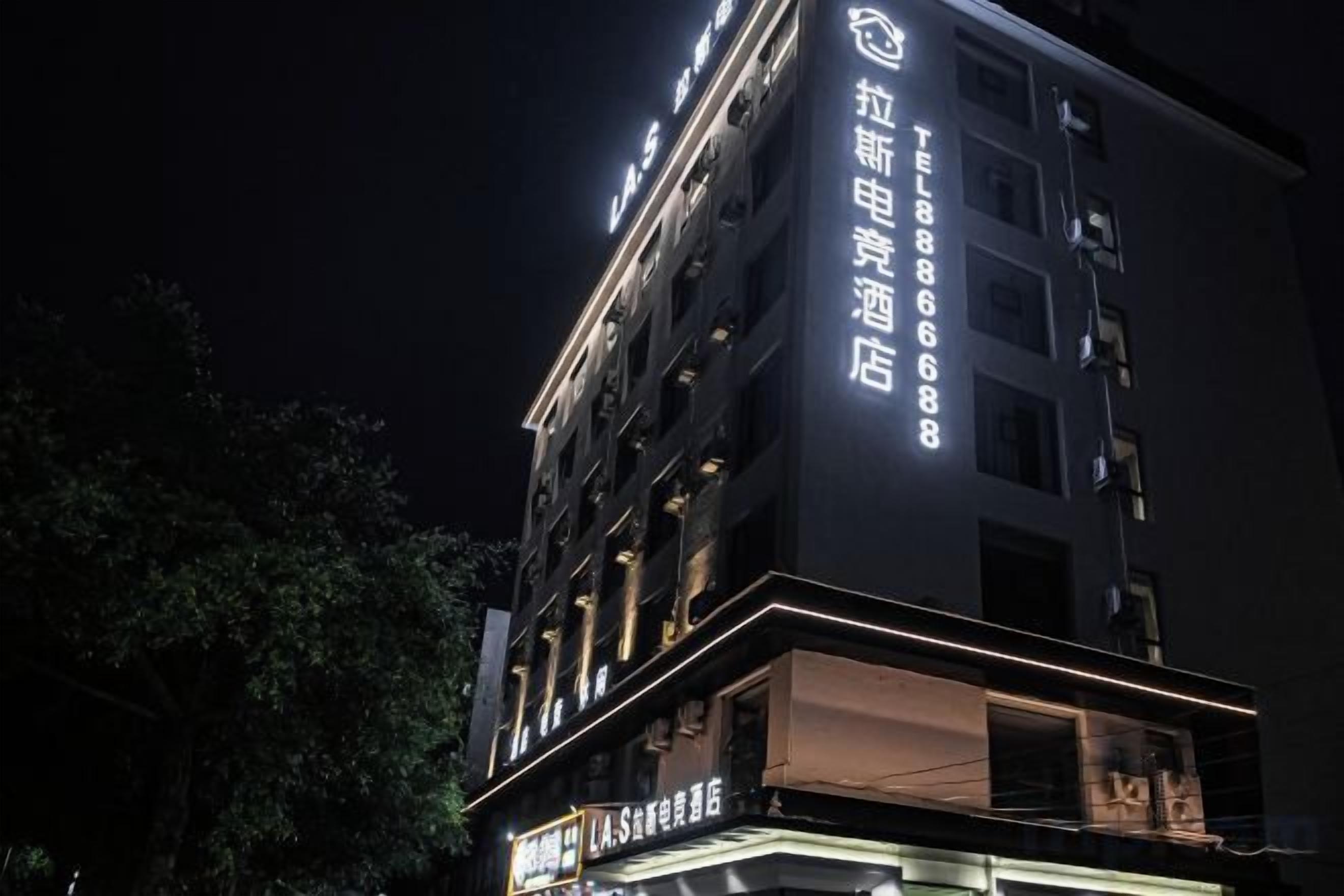 Un edificio de hotel de varios pisos con señalización iluminada y una entrada destacada.
