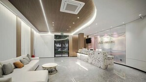 Una hall d'albergo moderna con una reception, un'area lounge e una parete di vetro che offre una vista.