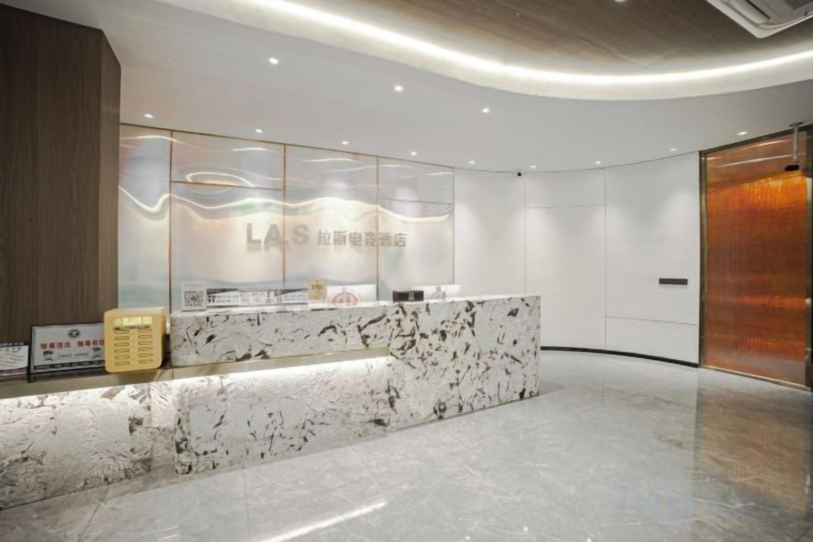 A reception area with a marble counter, glass display, and a wooden panel on the left.