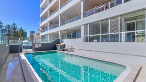 A modern building with a swimming pool, outdoor seating, and a view of the surrounding area. - Rainbow Pacific Unit 4 - Oceanfront Unit in Rainbow Bay, Coolangatta Linen and Wi-Fi included (Coolangatta)