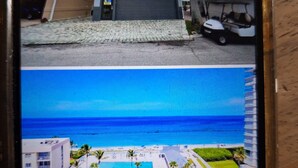 Zona residencial con garaje, un carrito de golf estacionado y una palmera.