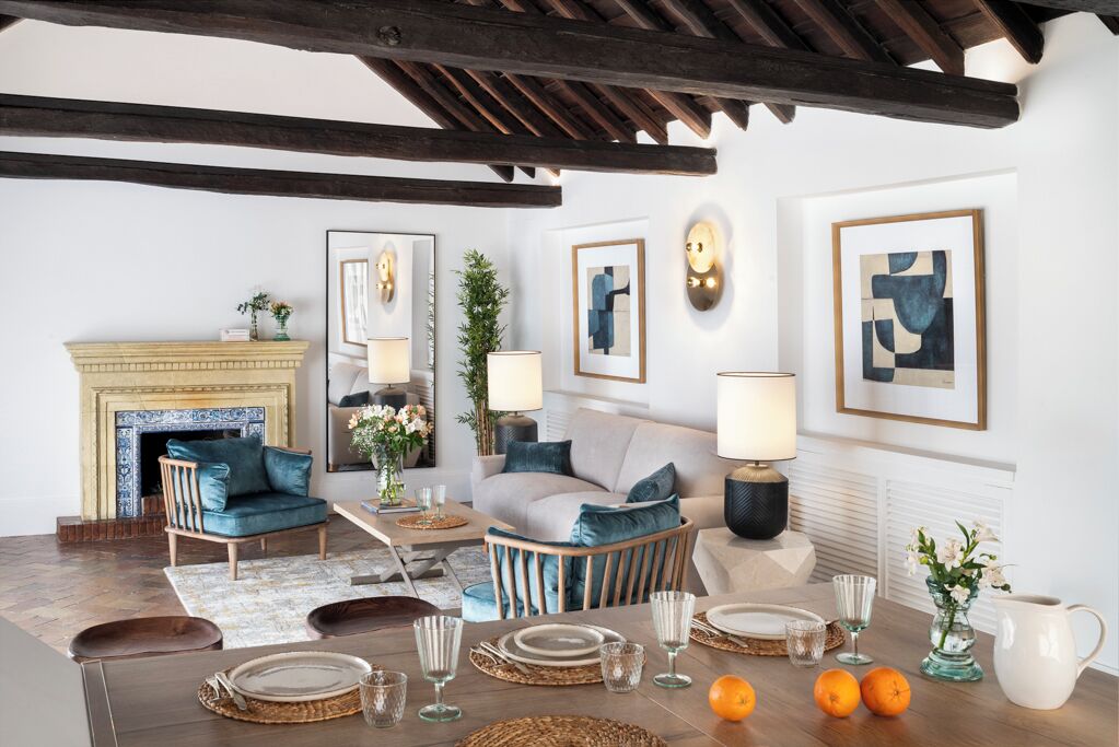A cozy living room with a fireplace, comfortable seating, and a dining area set for a meal.