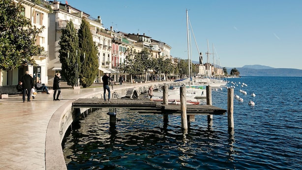 A waterfront promenade with buildings, a dock, and boats. - Villa Alberti 900m From Garda Lake (Salò)