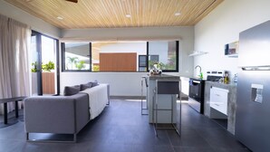 A modern kitchen with a built-in stove, a small island, and a refrigerator.