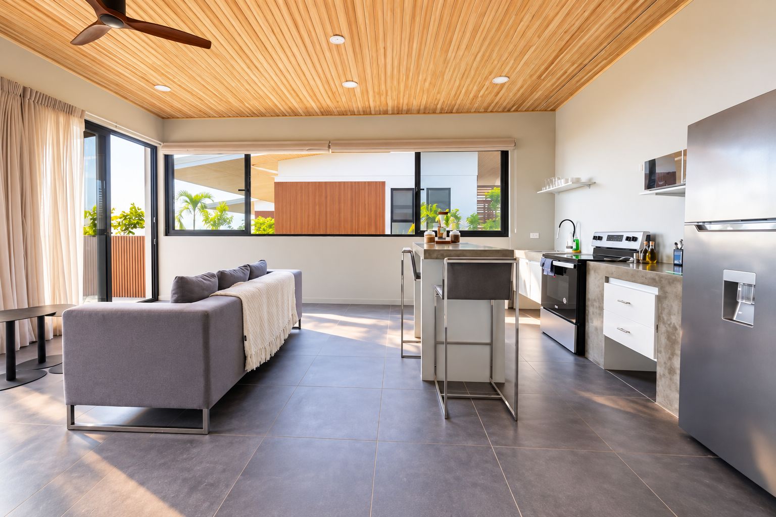 A modern kitchen with a built-in oven, a refrigerator, and a coffee machine.