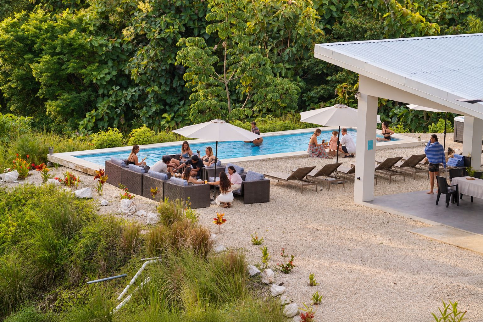 A poolside area with lounge chairs and a covered seating area.