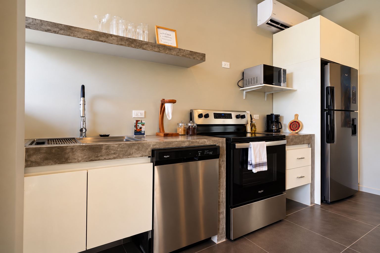 Una cocina moderna con electrodomésticos de acero inoxidable, lavavajillas y cafetera.