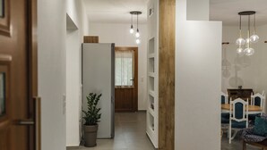 Un interior moderno con un largo pasillo, una zona de estar y un comedor.
