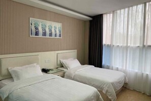 A hotel room with two beds, a nightstand, a telephone, and a painting on the wall. - Holiday Inn Express Strasbourg (Zherong)