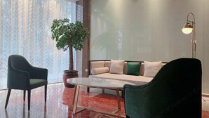 A modern living room with a sofa, two armchairs, a coffee table, and a potted plant. - Holiday Inn Express Strasbourg (Zherong)
