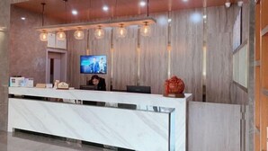 A modern reception desk with a marble top, a flat-screen TV mounted on the wall, and a decorative vase on the counter. - Holiday Inn Express Strasbourg (Zherong)