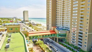 Ein Hotel mit Glasfassade, rotem Dach und Blick auf Strand und Meer.
