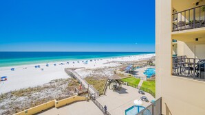A beachfront hotel with a pool, beach umbrellas, and a clear view of the ocean. - Phoenix Ii 2045 2 Bedroom Condo (Orange Beach)