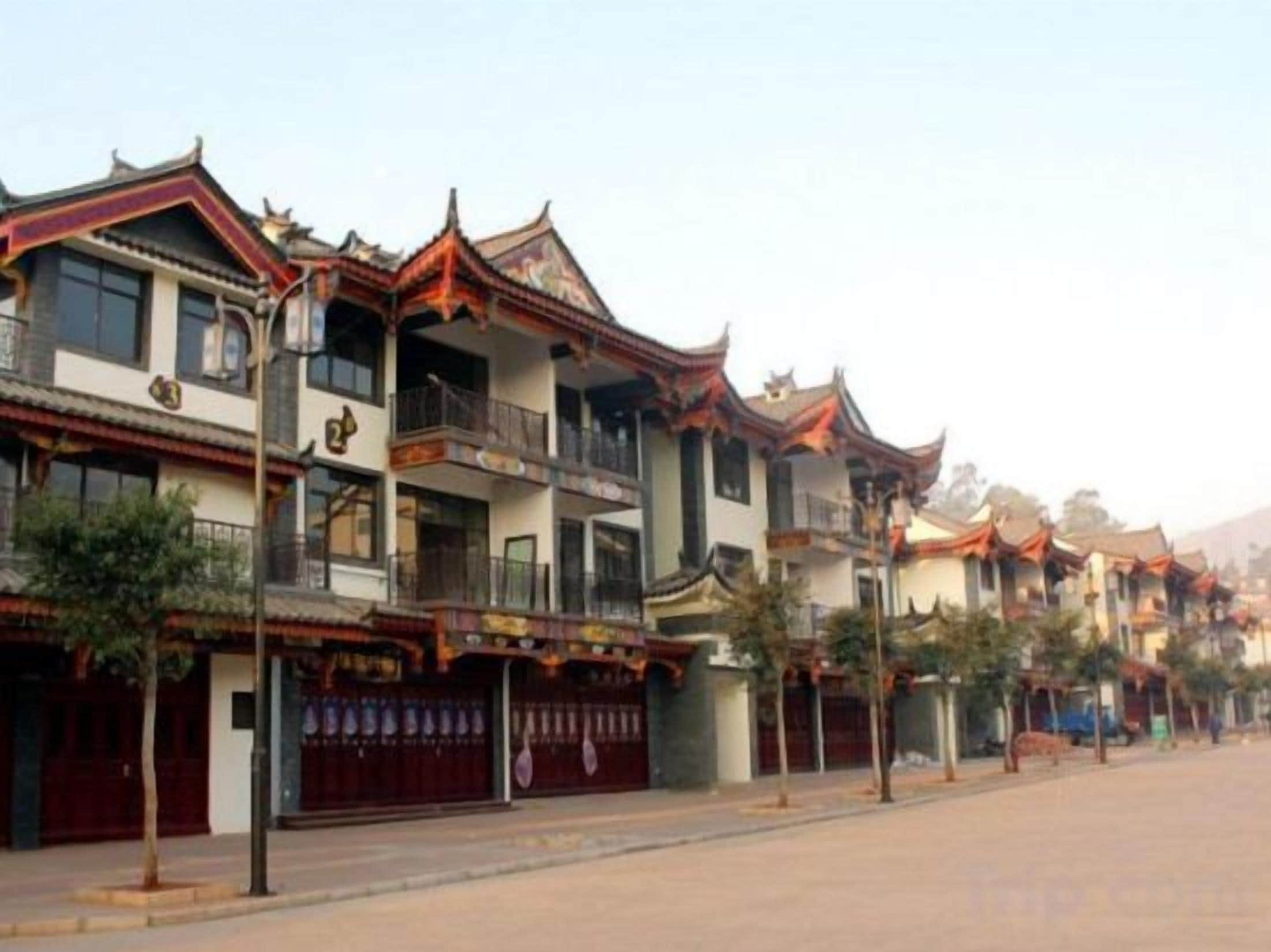 A row of traditional buildings with multiple stories, balconies, and a clear sky.